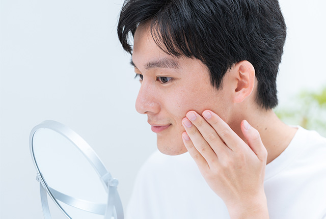 髭を鏡で確認している男性